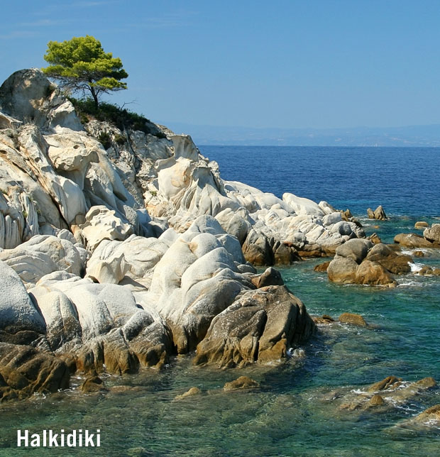 Halkidiki shoreline of white stones under the sunny skies with waters of the coast