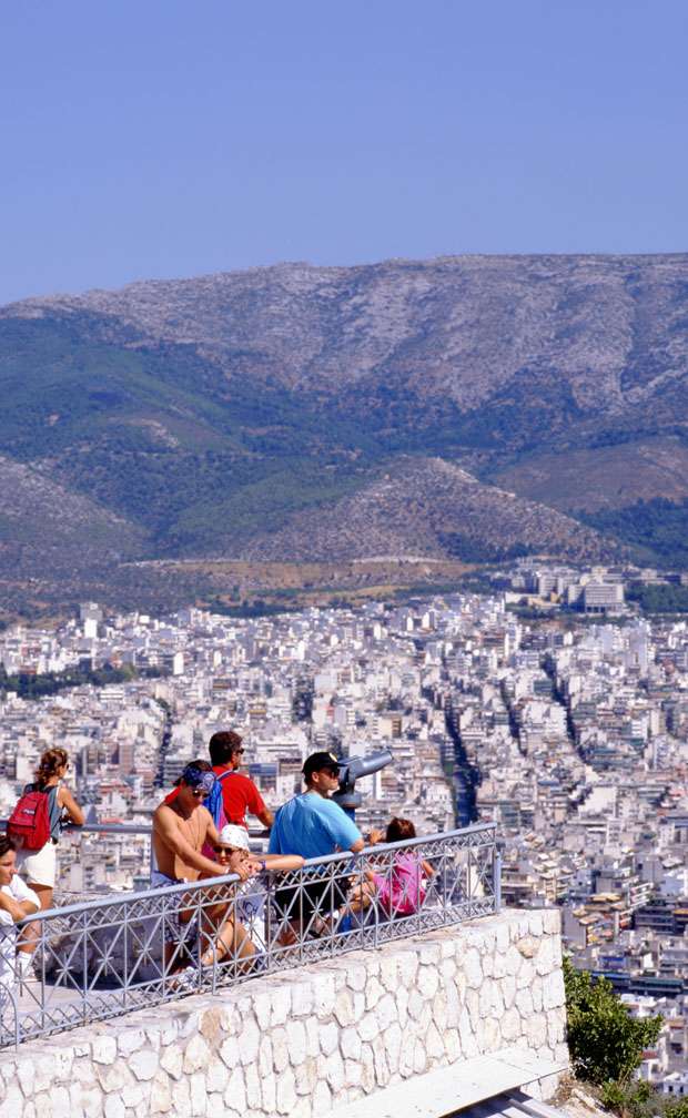Tourists looking out at the city in Athens Greece 