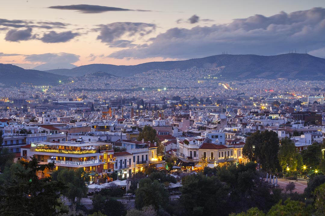 Sunset over Athens Greece - buildings lit at night
