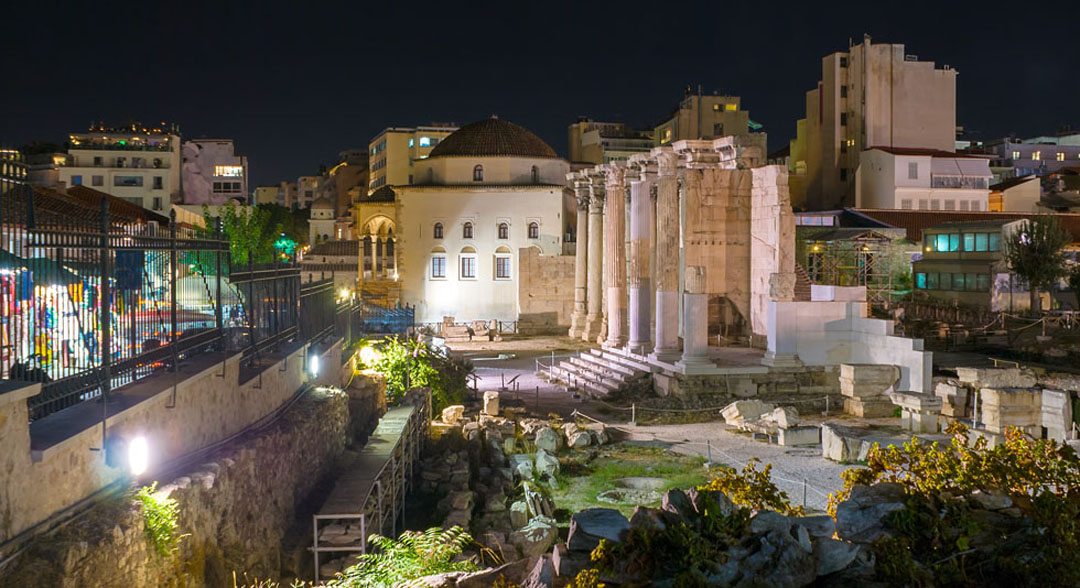 Ruins and city of Athens at night
