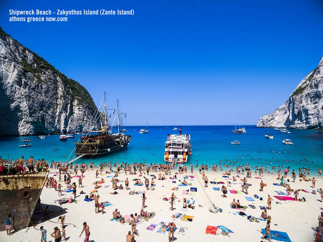 Beach tourists on navagio Beach - Smugglers Cove - SHipwreck Beach