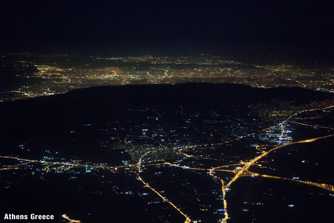 At night over Athens Greece with the dark silouhette of Ymittos in view