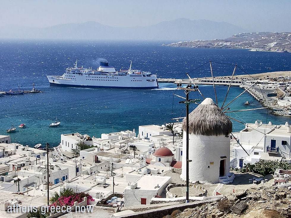 Mykanos windmill overlooking a cruise ship and the Aegean waters