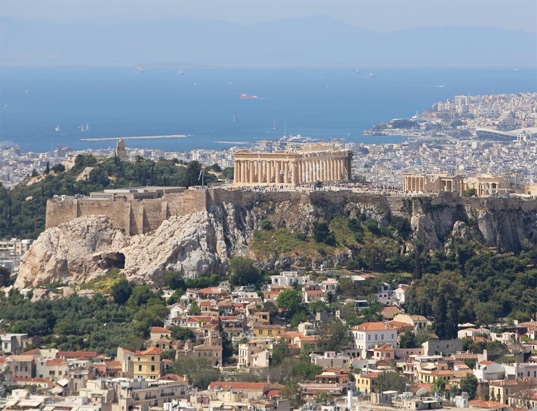 Acropolis under the sun in Athens with Saronic Gulf in the background