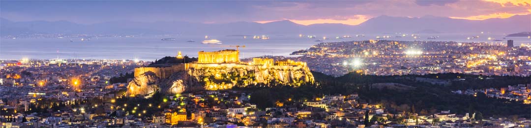 Athens Greece at Night with Saronic Gulf and sunset in the distance Athens Greece at Night with Saronic Gulf and sunset in the distance